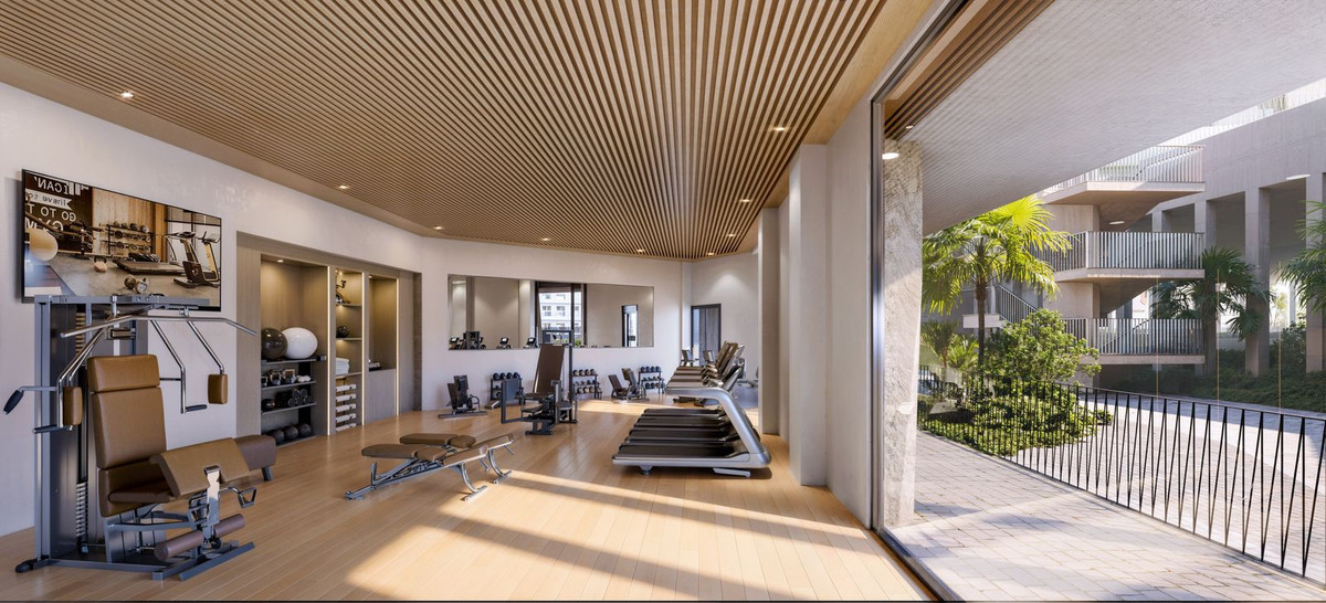 Modern home gym with large windows, outdoor view, and exercise equipment.