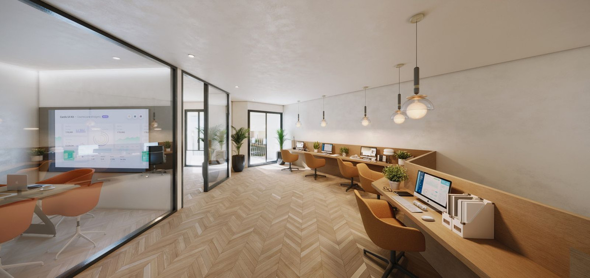 Modern office space with large windows, desks, and a glass meeting room.